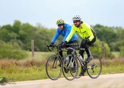Brightly dressed cyclists riding on a scenic bike trail in Texas.