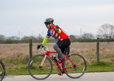 Vibrant cyclist wearing patriotic gear riding on a scenic trail during the Bluebonnet Express event.