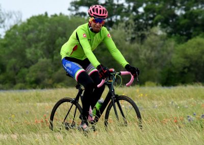 Vibrant cyclist riding through wildflower field on a lightweight road bike for outdoor biking adventures.