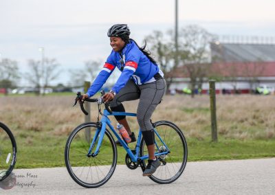 Bright woman riding Bluebonnet Express bike during outdoor cycling event in Texas.