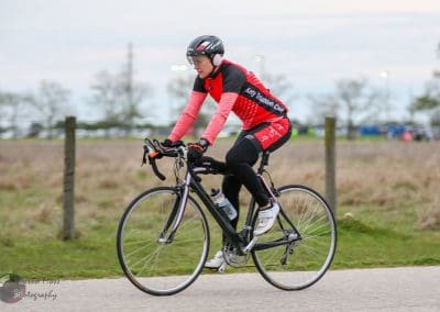 High-performance cyclist riding a bike outdoors for Bluebonnet Express race.