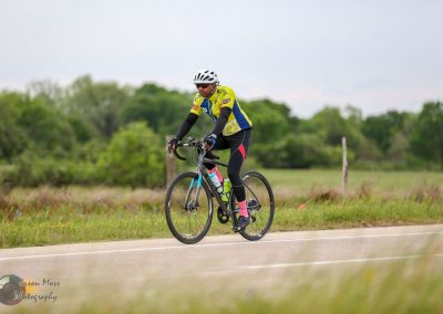 Vegan cyclist riding on rural road during daytime, eco-friendly biking outdoor activity.