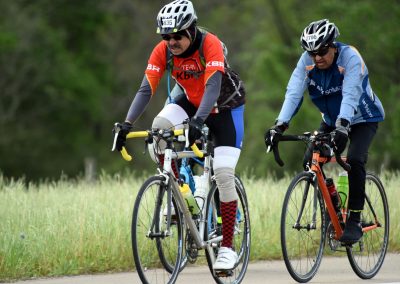 Riders cycling outdoors during a sports event on a sunny day in nature.