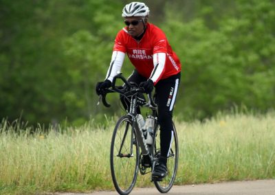 Cyclist riding a bike on a scenic trail during daytime, promoting outdoor cycling and fitness.