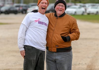 Joyful men in casual outdoor clothing smiling at Bluebonnet Express event.