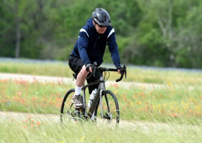 Man cycling on a trail in nature, wearing helmet and sportswear for outdoor biking.