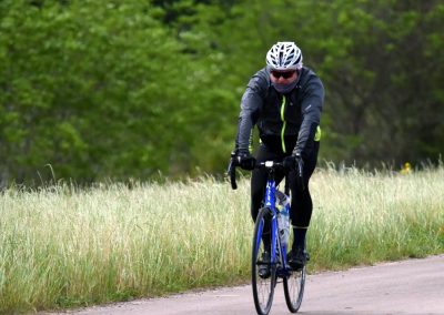 High-performance cyclist riding a bike on a scenic trail during daytime.