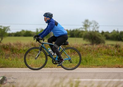 Vibrant cyclist riding across scenic outdoor trail in Bluebonnet Country, Texas.