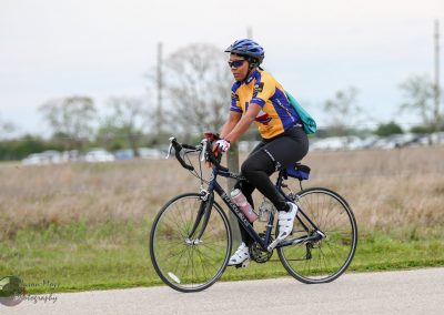 Active woman cyclist riding a bike outdoors during daytime.