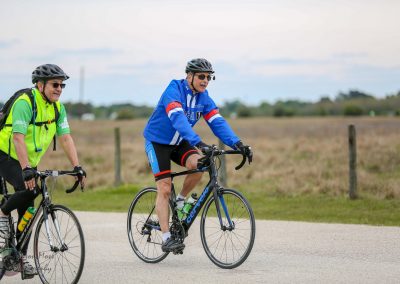 Young man riding a Bluebonnet Express bicycle in scenic countryside.