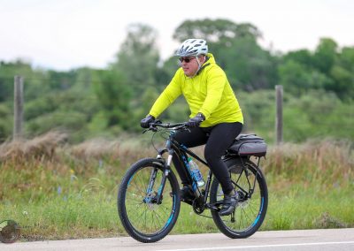 Vividly colored cyclist riding a mountain bike on scenic outdoor trail.
