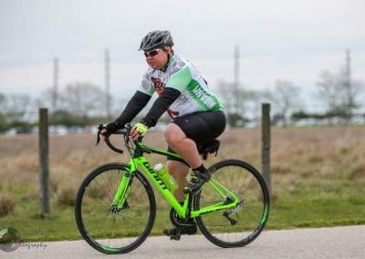 Vibrant green bicycle rider participating in Bluebonnet Express cycling event.