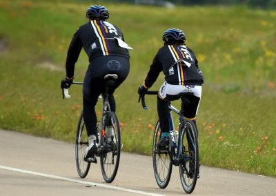 Riders enjoying a scenic bike ride featuring Bluebonnet Express jerseys on a peaceful trail.