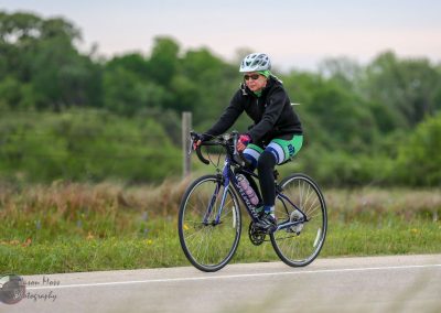 Cyclist riding a bike on a scenic trail during the Bluebonnet Express event.