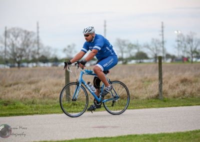 Bike rider wearing Bluebonnet Express jersey cycling outdoors, promoting Bluebonnet Express bike service.