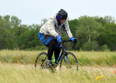 Vibrant cyclist enjoying a ride through natural scenery with Bluebonnet Express branding.