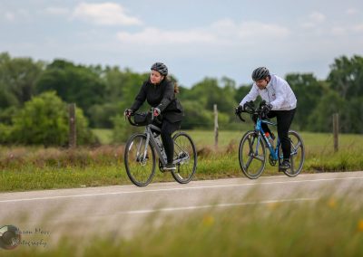 Comfortable cyclists enjoying Bluebonnet Express scenic bike ride on countryside road.