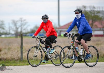 Comfortable outdoor biking during cool weather, wearing masks and jackets for safety and warmth.