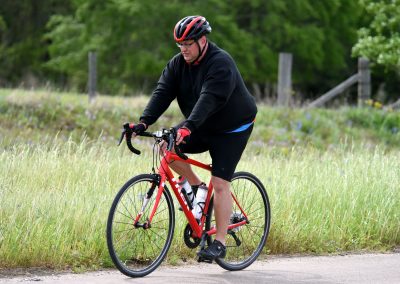 Man riding a red bike on a scenic trail in nature during daytime.