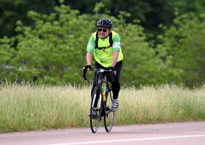 Vibrant cyclist riding through scenic countryside on Bluebonnet Express route in Texas.