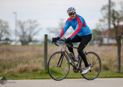 Comfortable cyclist riding a road bike on a scenic outdoor trail at Bluebonnet Express.