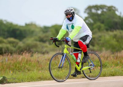 Bright yellow Trek road bike with rider in athletic gear cycling on scenic trail.