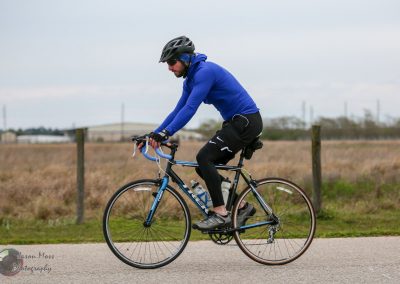 Rider on a blue and black road bike during Bluebonnet Express cycling event, enjoying scenic outdoor ride.