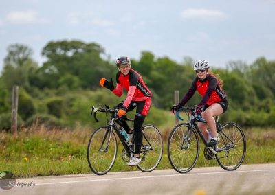 Brighton biking duo riding bicycles on scenic Texas countryside for Bluebonnet Express event.