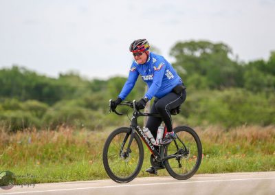 Rider cycling on a scenic outdoor trail during daytime, promoting outdoor adventure and fitness.
