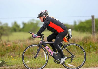 Rider on Black and Pink Road Bicycle Cycling on Scenic Trail During Day.