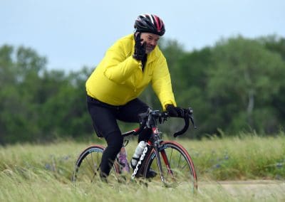 Bright yellow jacket worn by a cyclist riding through the countryside, promoting outdoor biking activity.