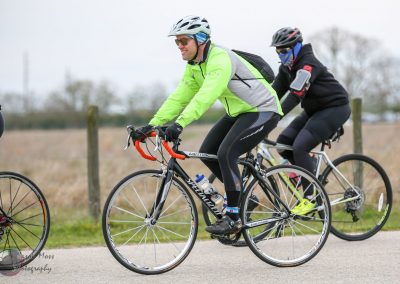 Bright green cycling jacket, bike gear, riding bike on scenic outdoor trail.