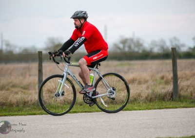 Cyclist riding a bike along a rural trail during daytime for Bluebonnet Express event.