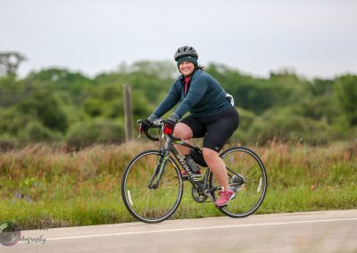 Vegan woman cycling outdoors on a Specialized bike with a scenic background.