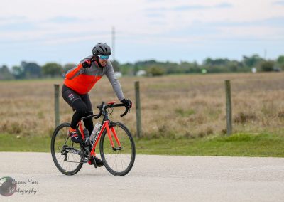 High-performance cyclist on Bluebonnet Express bicycle on rural road in Texas.