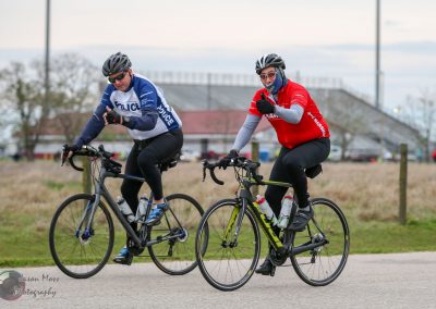 Bike ride at Bluebonnet Express cycling event, featuring cyclists in team gear on road bikes.