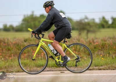 Bright yellow Basso Dolomite road bike with rider in cycling gear on scenic outdoor trail.