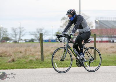 Bluebonnet Express cyclist riding on a paved path with helmet and gear.