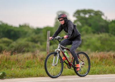 Vibrant female cyclist riding a mountain bike on a scenic trail during daytime.