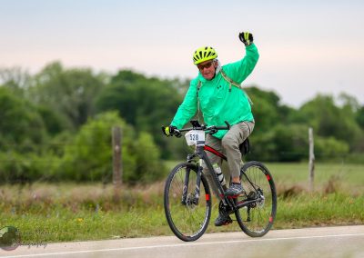 Bright green cyclist helmet and jacket on Bluebonnet Express bike ride event.