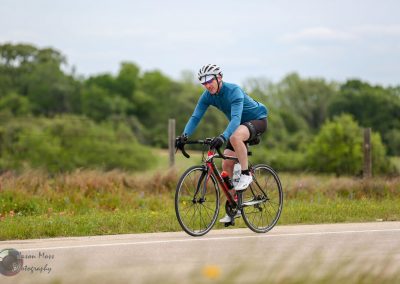 Bright blue cyclist jersey and bike on scenic outdoor trail - Bluebonnet Express cycling ride.