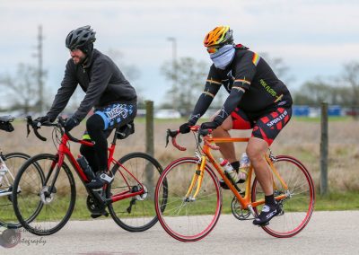 High-energy cyclists riding on a scenic outdoor trail, promoting Bluebonnet Express bike tours and community events.
