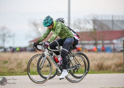 High-performance cyclist riding a specialized bike during a race, promoting Bluebonnet Express eco-friendly transportation.