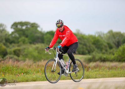 Vibrant cyclist riding on scenic Texas landscape during Bluebonnet Express bike event.