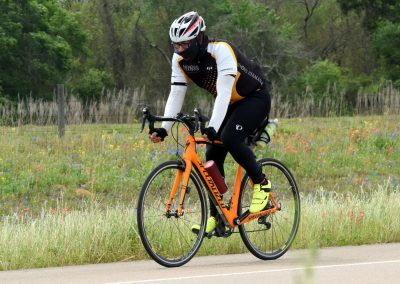 Bright orange Specialized road bike for fast cycling on scenic outdoor trails.