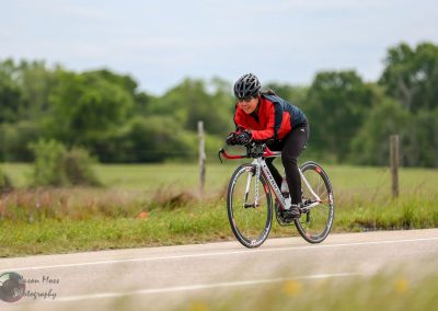 Rider on a bicycle during outdoor ride with scenic green landscape.