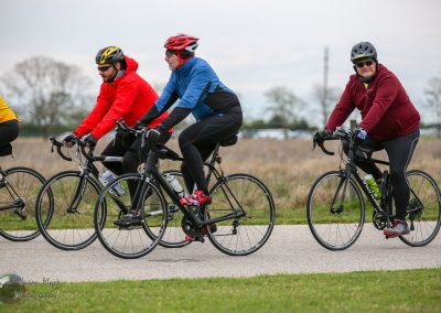 Vibrant cyclists riding on a scenic outdoor trail with helmets and athletic gear for biking adventures.