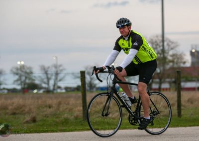 High-performance cyclist riding a bike outdoors, promoting Bluebonnet Express bike services.