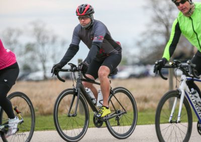 Vibrant group of cyclists riding on a trail in athletic gear during daytime.