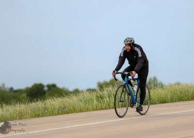 Bright blue bike on scenic trail under cloudy sky, cyclist enjoying outdoor adventure.